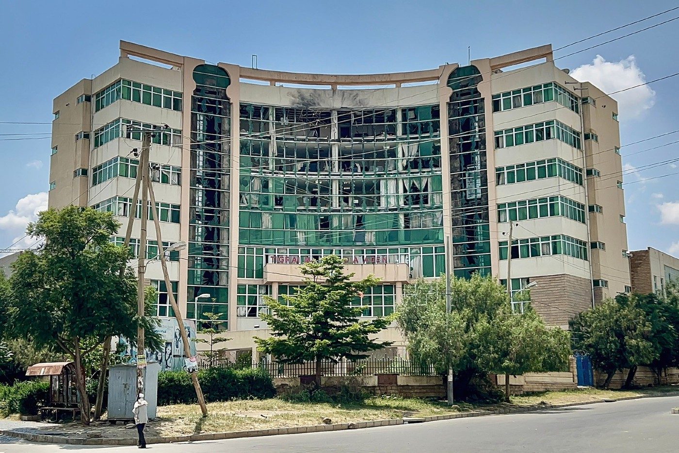 A multi-storey office building with broken and damaged windows