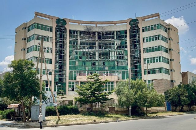 A multi-storey office building with broken and damaged windows