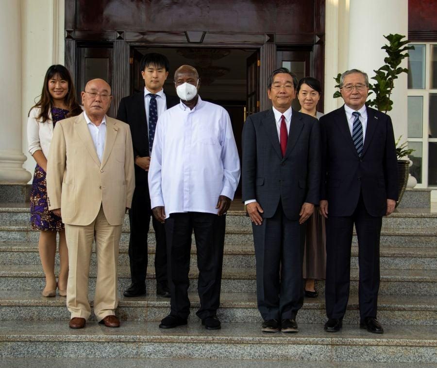 Officials and visitors pose for a group photograph on the steps of a building