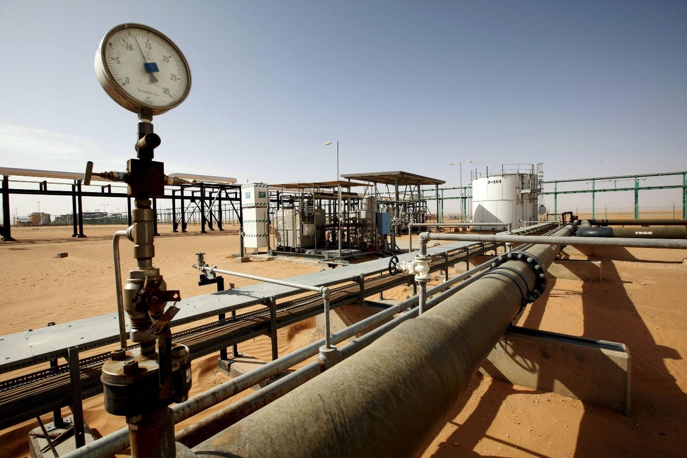 A pressure gauge and pipework at an oil facility in the desert
