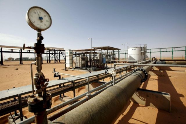 A pressure gauge and pipework at an oil facility in the desert