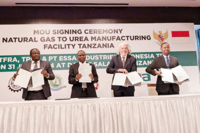 Officials hold signed documents at a signing ceremony for a natural gas to urea facility in Tanzania