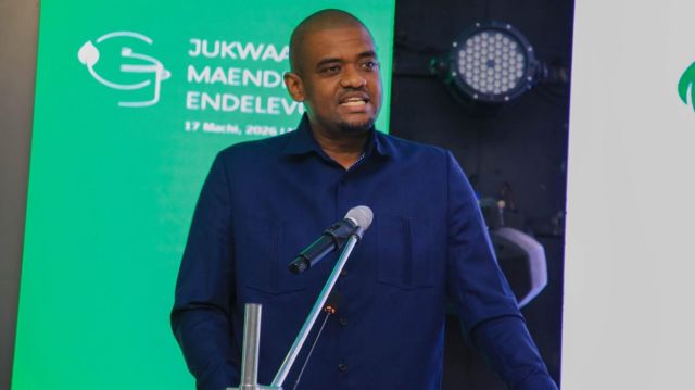 A man in a dark shirt speaks at a podium at a youth employment event